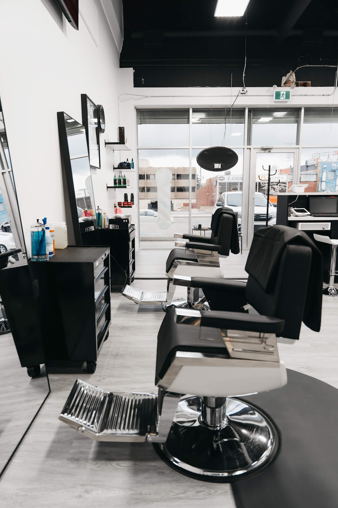 Macleod Trail Barbers Barbershop chairs sideview facing a sunlit storefront.